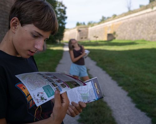 Enfant tenant un livret de visite ludique